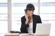 Femme souriante au téléphone devant un ordinateur portable