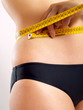 Woman measuring her abdomen Woman measuring her abdomen