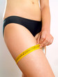 Woman measuring her thigh Woman measuring her thigh