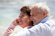 Foto: Portrait d'un couple de seniors souriants au bord de la plage Portrait d'un couple de seniors souriants au bord de la plage