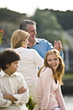 Photo: Mature couple dancing outdoors, daughter and son in foreground Mature couple dancing outdoors, daughter and son in foreground