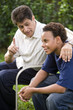 Photo: Interracial father and teenage son together in back yard Interracial father and teenage son together in back yard