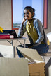 Young woman in unfinished office space with unpacked boxes