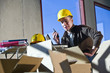Construction worker in unfinished room surrounded by boxes