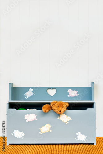 Foto: Teddy bear poking his head out of a child's toy box. Teddy bear poking his head out of a child's toy box.