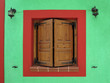Wooden window shutters on the green wall