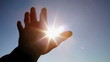 Hand in silhouette raised up to the sun Hand in silhouette raised up to the sun
