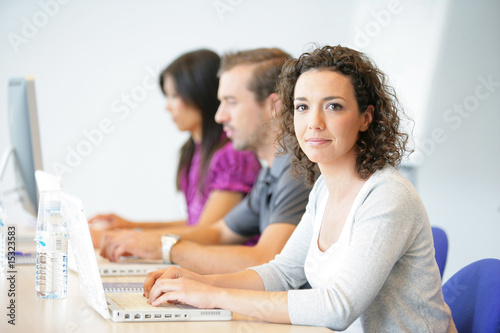 Femme souriante au bureau en formation commerciale Femme souriante au bureau en formation commerciale