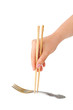 Hand with chopsticks and fork