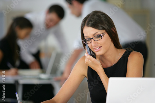 Femme souriante téléphonant en écrivant sur un document Femme souriante téléphonant en écrivant sur un document