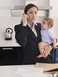 Foto: Mother holding baby daughter while talking on phone in kitchen Mother holding baby daughter while talking on phone in kitchen