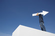Man outdoors on wall with blank arrow