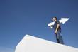 Man outdoors on wall with blank arrow