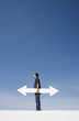 Man outdoors on wall with blank arrow