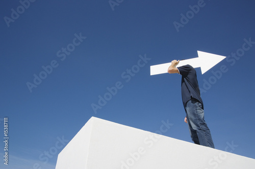 Photo: Man outdoors on wall with blank arrow Man outdoors on wall with blank arrow