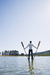 Man standing on water with oars