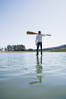 Man standing on water with oars