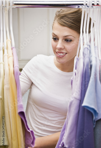 Photo: Beautiful Young Woman Looking Through Closet Beautiful Young Woman Looking Through Closet