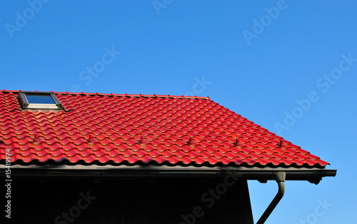 rotes Ziegeldach Dachrinne blauer Himmel Haus Dachfenster
