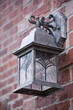 Iron lantern hanging outdoors on a brick wall