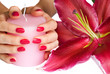 Hands with pink manicure, candle and lily
