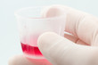 Cough syrup in cup held by medical professional Cough syrup in cup held by medical professional