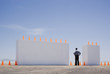 Man standing between two monolithic barriers lined with safety cones
