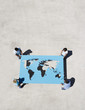 Four people holding world map outdoors
