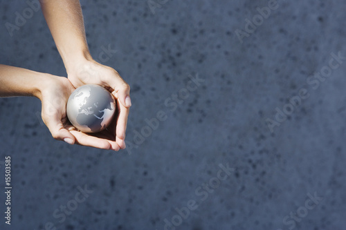 Photo: Detailed View of hands holding globe outdoors Detailed View of hands holding globe outdoors
