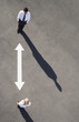 Arrow on pavement pointing to businessman and woman