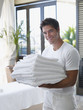 Man with a pile of towels in his arms