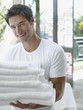 Man with a pile of towels in his arms