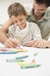 A father and son colouring together