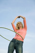 Young Woman With Hula Hoop Around Waist Smiling