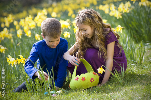 Photo: Girl and Boy Collecting Easter Eggs Girl and Boy Collecting Easter Eggs