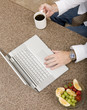 A businessman on his computer while having breakfast A businessman on his computer while having breakfast