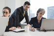 View of businesspeople in a meeting with laptops.