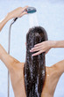 Female holding douche and washing hair