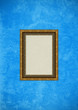 Grunge blue stucco wall with empty picture frame