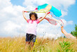 A little pretty girl with scarf above head on medow
