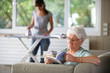 Photo : femme senior assise sur un canapé bouquinant près d'une femme femme senior assise sur un canapé bouquinant près d'une femme