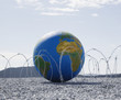A globe entangled in barbed wire
