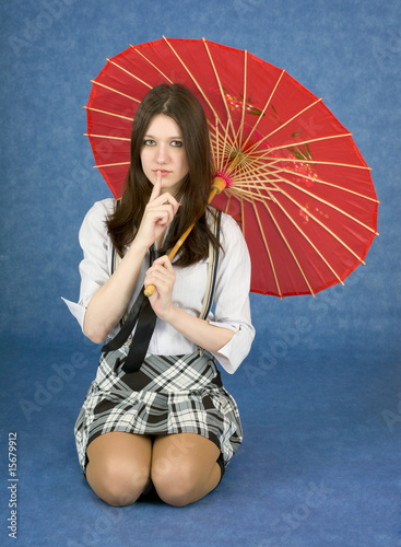 Photo: Young woman with umbrella on blue background Young woman with umbrella on blue background