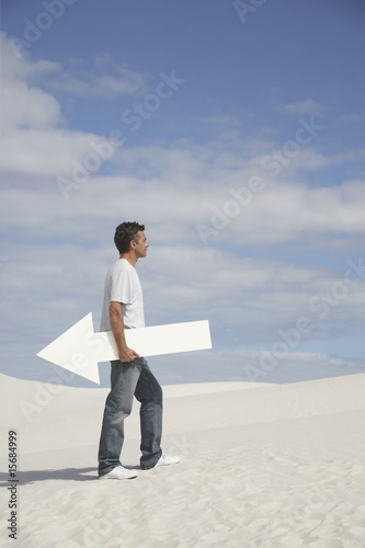 Photo: A man holding a directional arrow A man holding a directional arrow