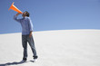 A man with a traffic cone in the middle of nowhere