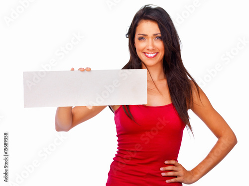 Foto: Smiling beautiful woman holding a white board on white Smiling beautiful woman holding a white board on white