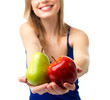 Midsection of young woman holding fruit in hands, smiling.