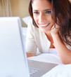 Foto: Closeup of a beautiful woman lying on bed using laptop Closeup of a beautiful woman lying on bed using laptop