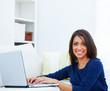 Portrait of a smiling young woman using a laptop
