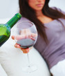 Closeup of wine being poured in a wineglass held by a lady